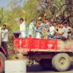 A truck containing joyful Indian men.